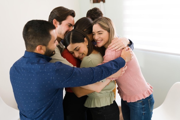 Offering support to the new members of a rehab group. Young people hugging and feeling proud and happy during a therapy session