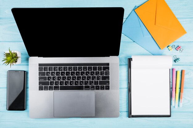Free photo office blue desk with laptop and school materials
