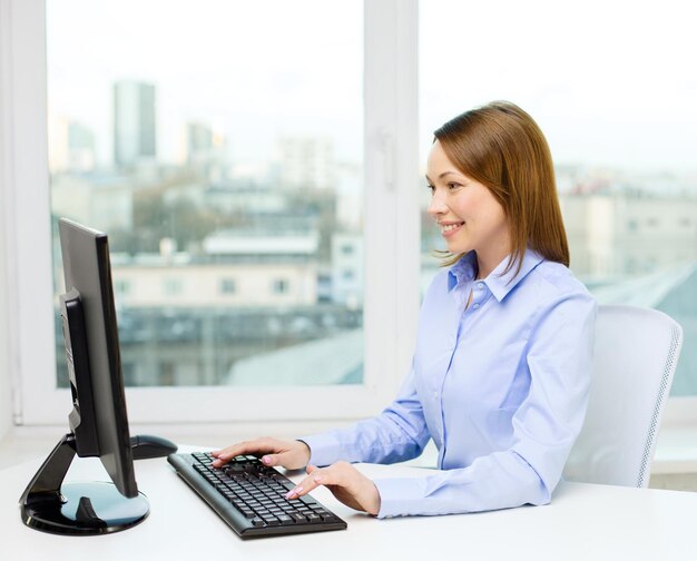 Концепция офиса, бизнеса, образования, технологий и интернета - улыбающаяся деловая женщина или студентка с компьютером