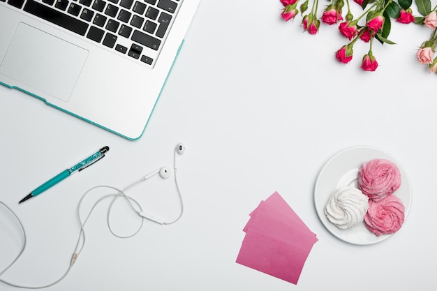 Office desk table with computer, supplies and flowers