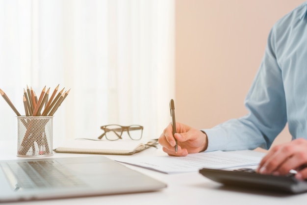 Free photo office desktop with laptop and a business man