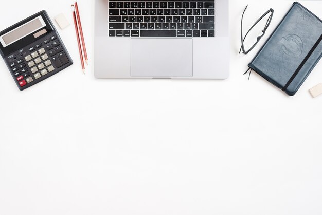 Office desktop with laptop and a calculator