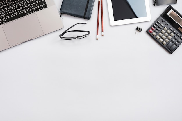 Office desktop with laptop and a calculator