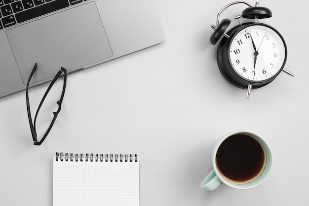 Office desktop with laptop and a clock