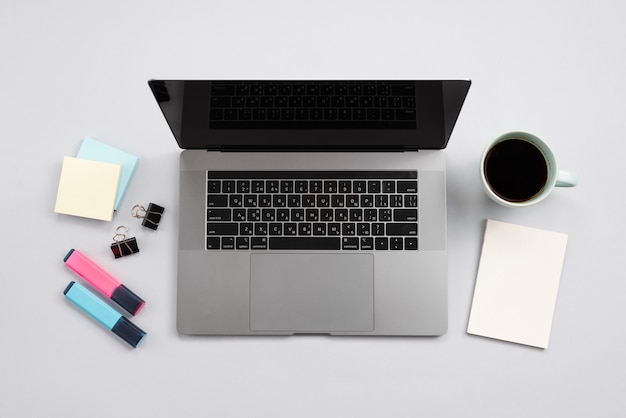 Office desktop with laptop and a coffee cup