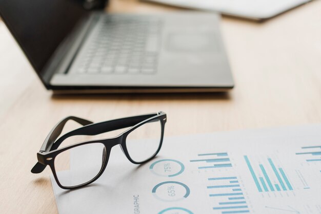 Office desktop with laptop and a glasses