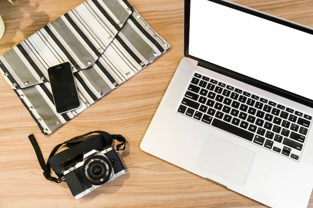 Office desktop with laptop and a photo camera