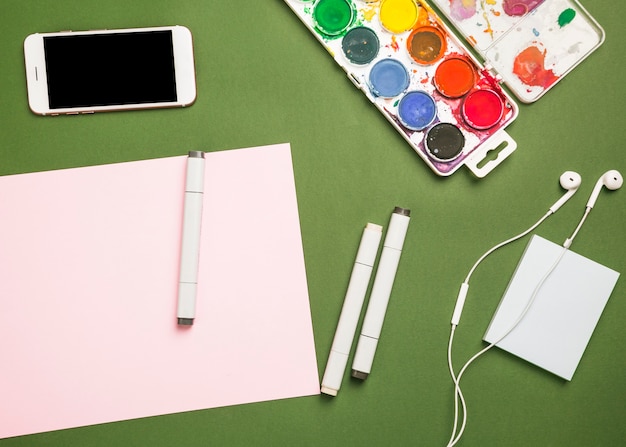 Бесплатное фото Офисный рабочий стол с мобильным телефоном и краской