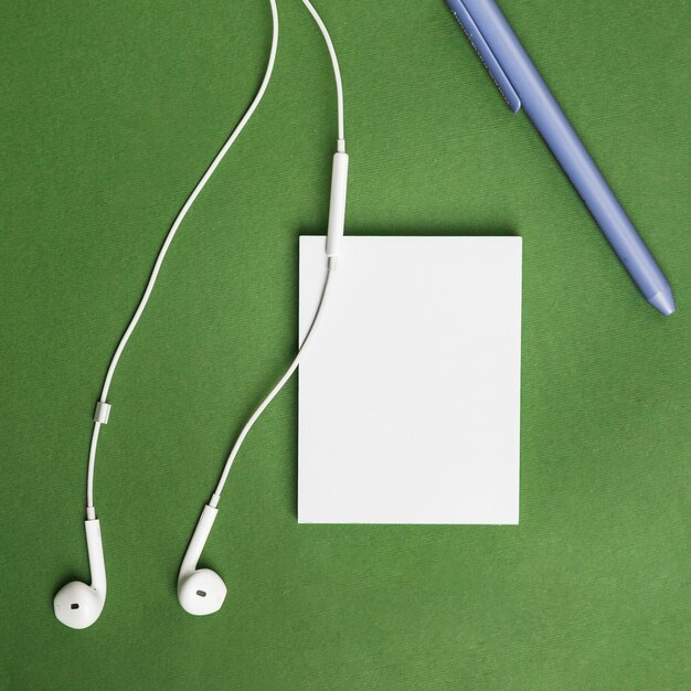 Office desktop with a paper sheet and earphones