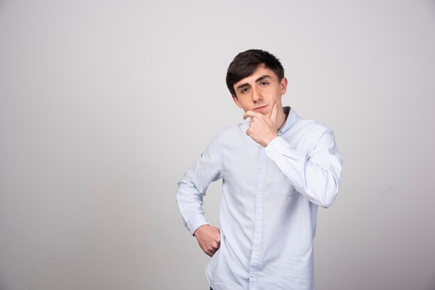 office employee in formal wear showing thinking on gray wall.