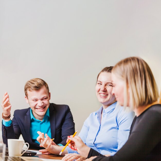 Office employees sitting at desk smiling