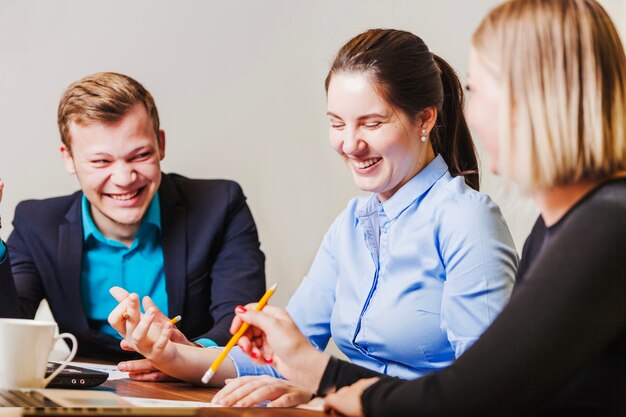 Office employees sitting at desk smiling