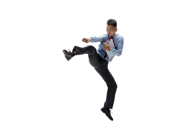 Office man practicing taekwondo on white wall