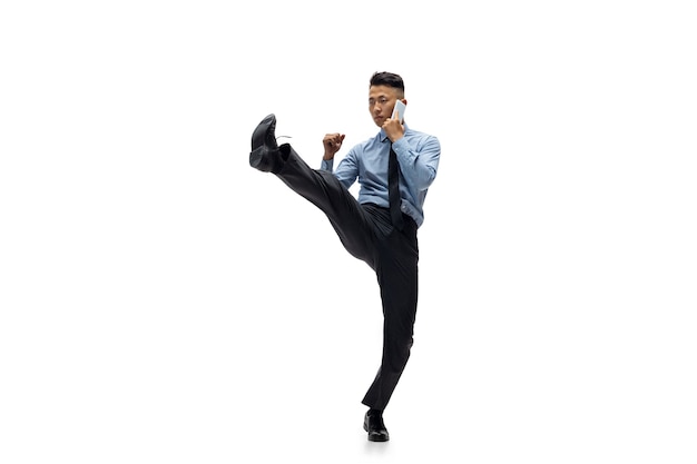 Office man practicing taekwondo on white wall