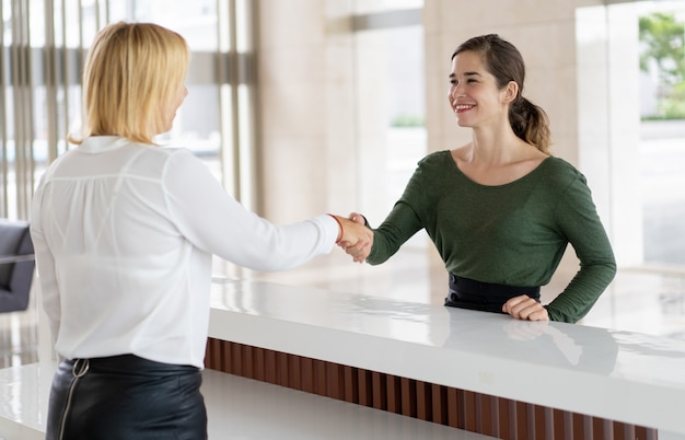 Office receptionist greeting corporate partner