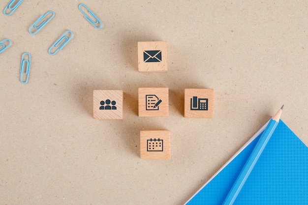 Office supplies concept with icons on wooden cubes, stationery set flat lay.