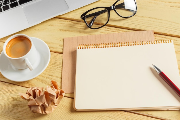 Office table background with coffee cup, pencils and computer keyboard. Business workplace or workspace concept.