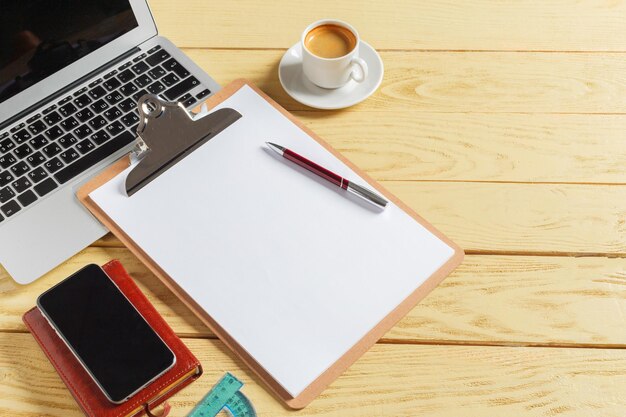 Office table background with coffee cup, pencils and computer keyboard. Business workplace or workspace concept.