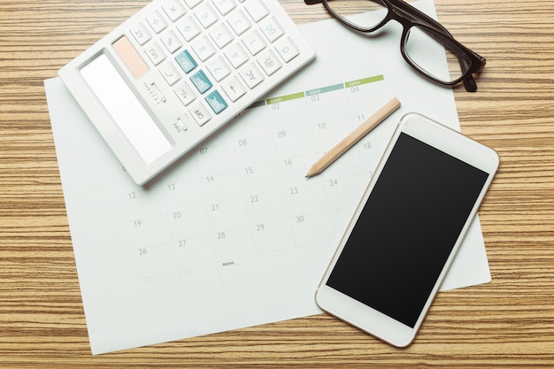 Office table with smartphone on it view from above