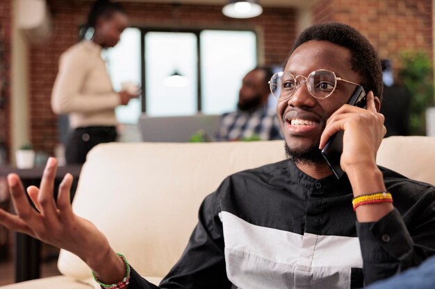 Office worker talking on mobile phone call with manager, working on company presentation and business report at workplace. Chatting on smartphone line to create research information online.