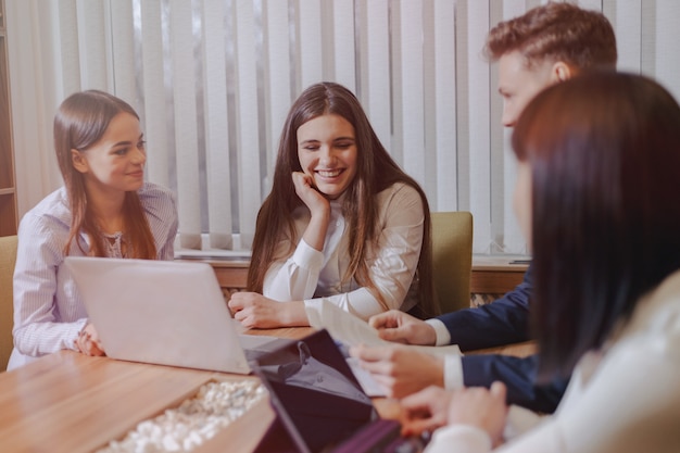 Office workers at a meeting using laptops