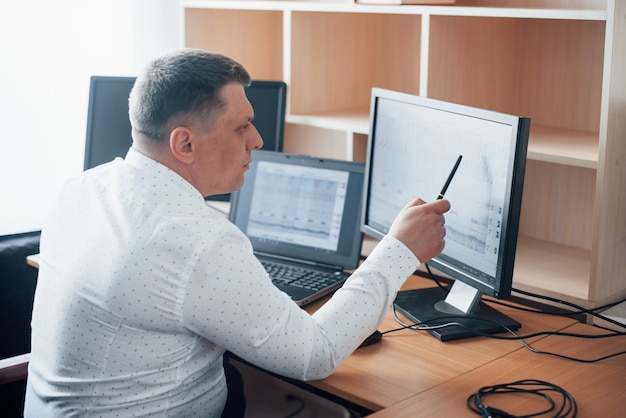 In official white shirt. Polygraph examiner works in the office with his lie detector's equipment