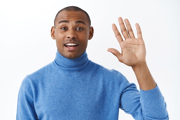 Free photo oh hello, nice to meet you. portrait of surprised african american man greet friend, didnt expect see person