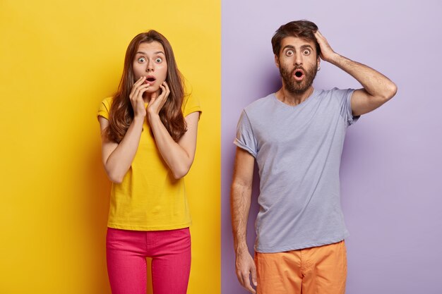 Oh my God! Portrait of shocked stunned female and male popping eyes at camera, learn terrible news, pose in stupor