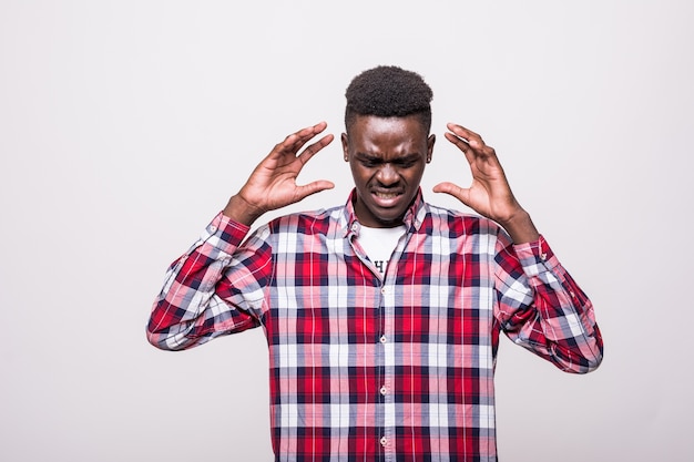 Oh no. Attractive unhappy dark-eyed afro-american man wearing a white shirt and looking dissatisfied and having his hands on his head