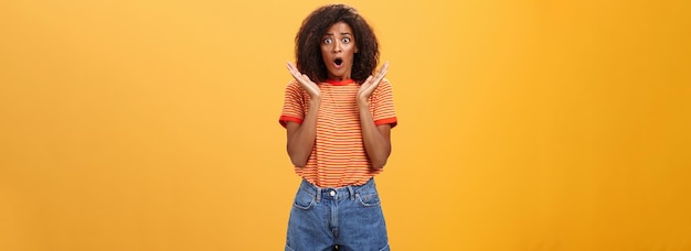 Oh no what happened worried african american sister with curly hair in trendy striped tshirt and den