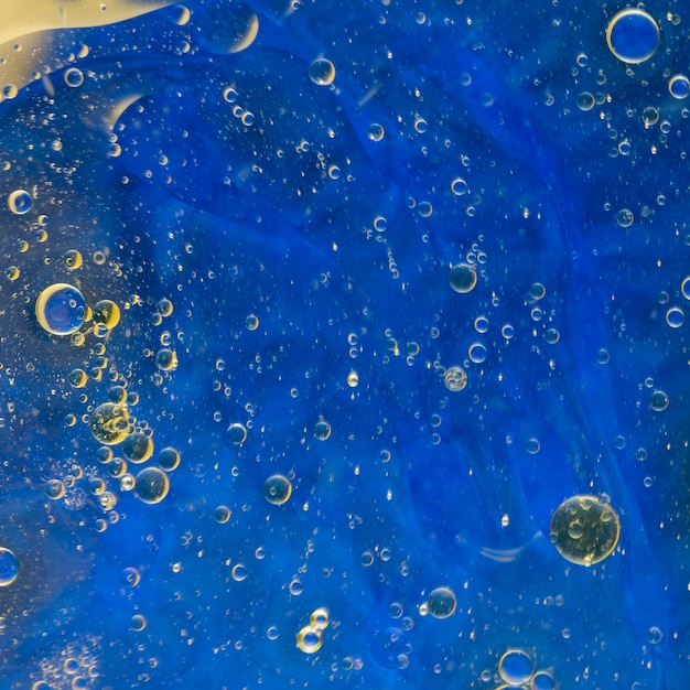 Oil bubbles floating on blue watercolor background