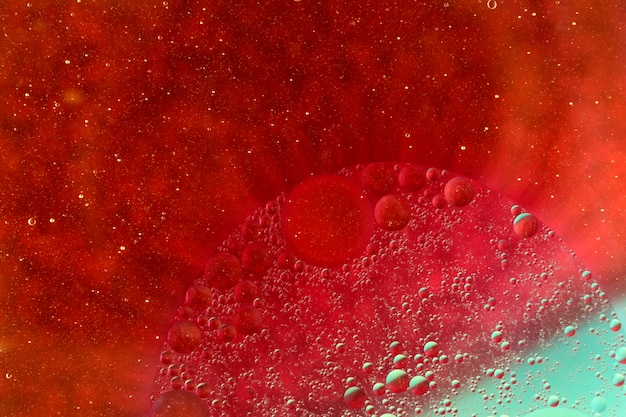 Oil bubbles floating on vibrant red background