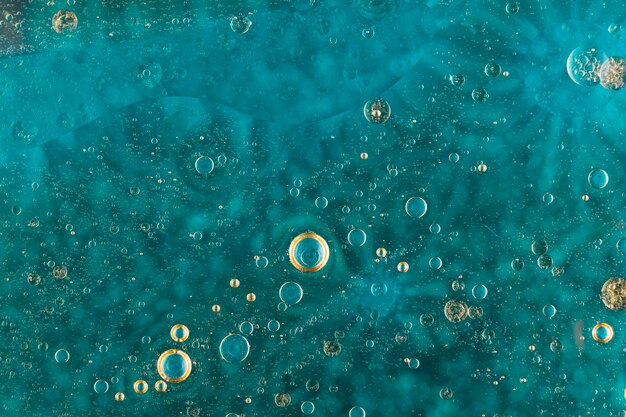 Масляные пузырьки над поверхностью зеленой воды