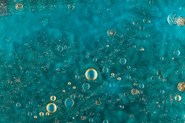 Oil bubbles over green water surface