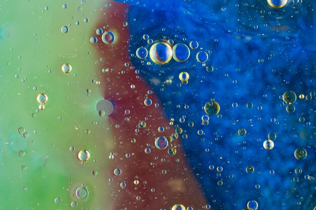 Oil bubbles over the painted textured backdrop