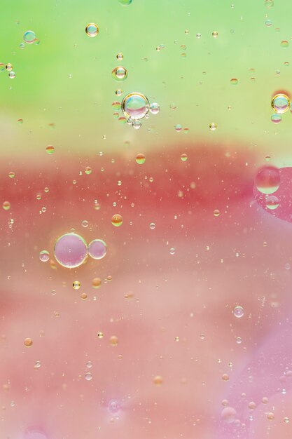 Oil drops in water on colored background