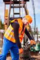 Free photo oil man tightening lug nuts with industrial wrench in oil field