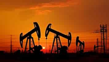 Foto gratuita piattaforme petrolifere al tramonto create con la tecnologia generative ai