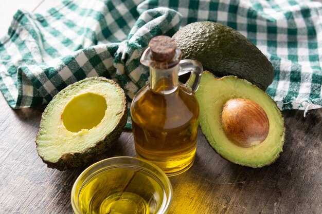 Oil and ripe fresh avocado on rustic wooden table