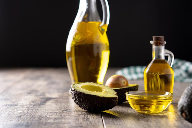 Oil and ripe fresh avocado on rustic wooden table