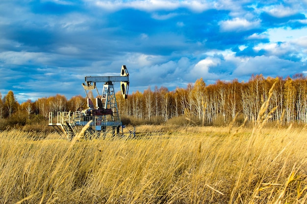 Oil rocking in the field in the fall. russia. republic of bashkortostan. rosneft, bashneft, background of blue sky in the summer