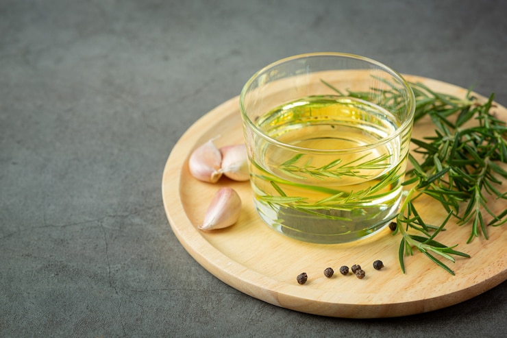 Free Photo oil with rosemary on table
