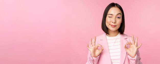 Okay excellent businesswoman in corporate suit showing ok approval gesture recommending smth give po