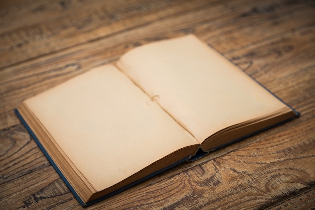 Free photo old book open on a wooden table