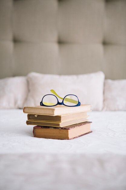 Old books and glasses on bed