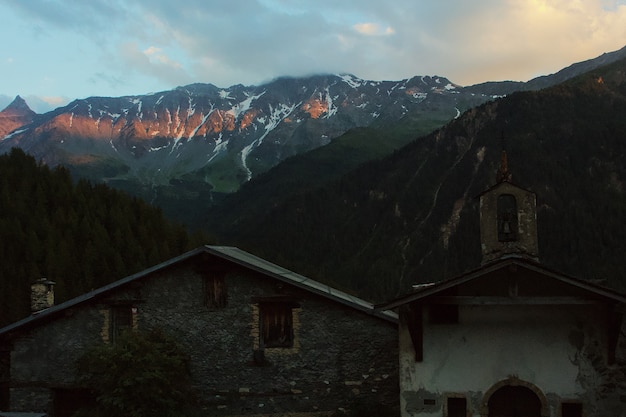 Foto gratuita vecchia chiesa circondata da montagne e alberi