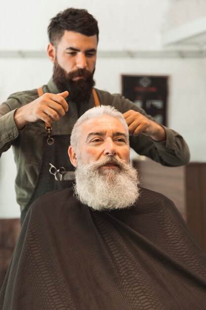 Old client getting haircut at hair salon