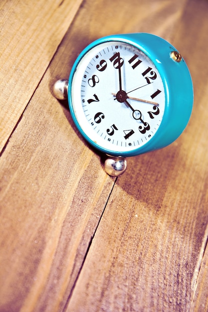 Old clock on the wooden background.