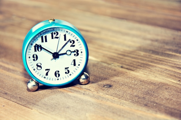 Old clock on the wooden background.