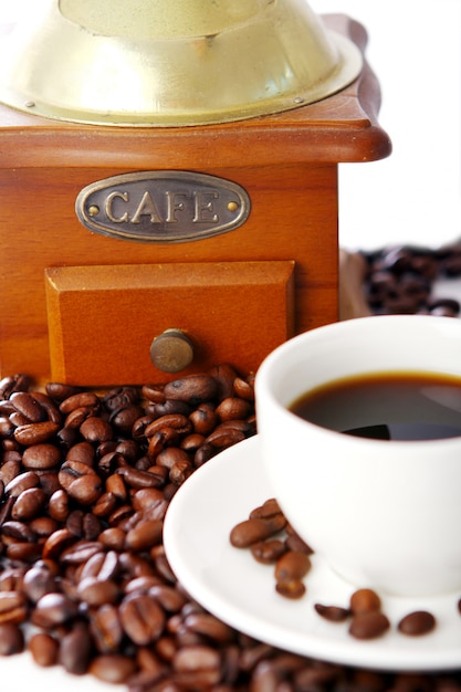 Old coffee grinder with white cup